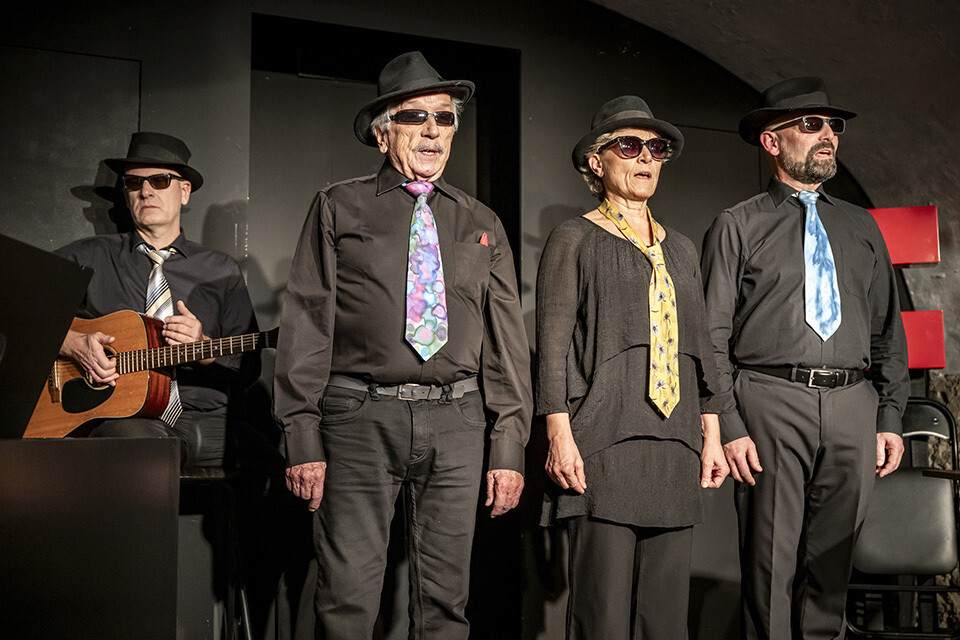 Cabaret ScherzGrenze mit vier Künstlerinnen und Künstlern in schwarzen Outfits, Hüten und Sonnenbrillen auf der Bühne, zum Programm «Alles im Griff!?» im Schlosskeller Interlaken.